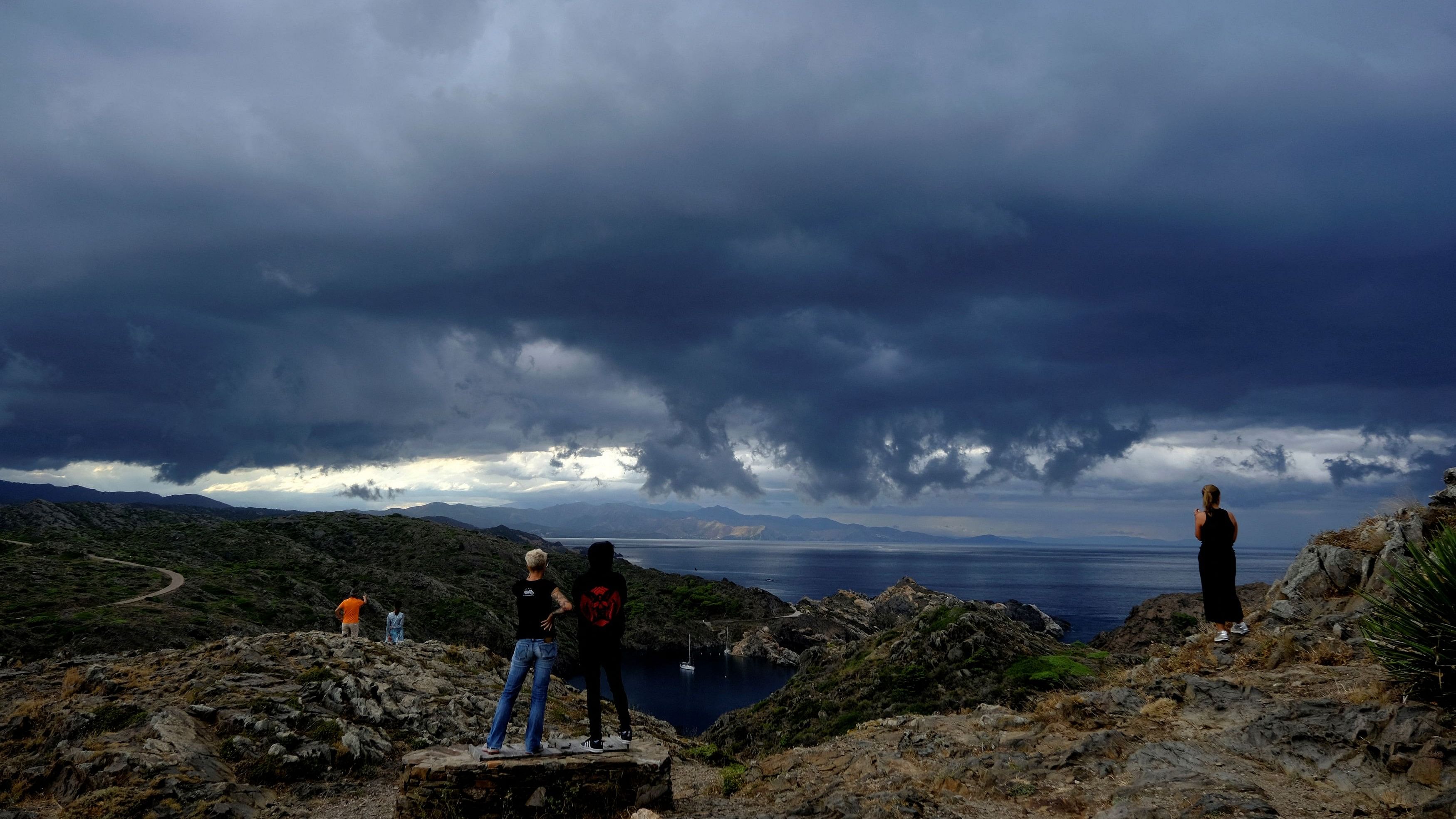 <div class="paragraphs"><p>Locals and tourists look at the Cap de Creus Natural Park in front of the Mediterranean Sea, near Cadaques</p></div>